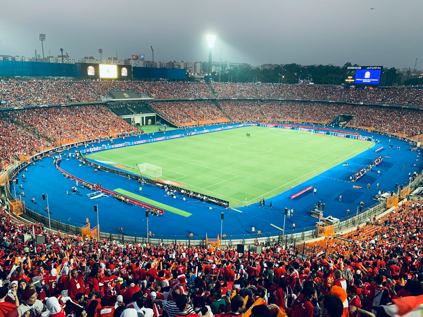 Crowded football stadium filled with fans during an evening game.