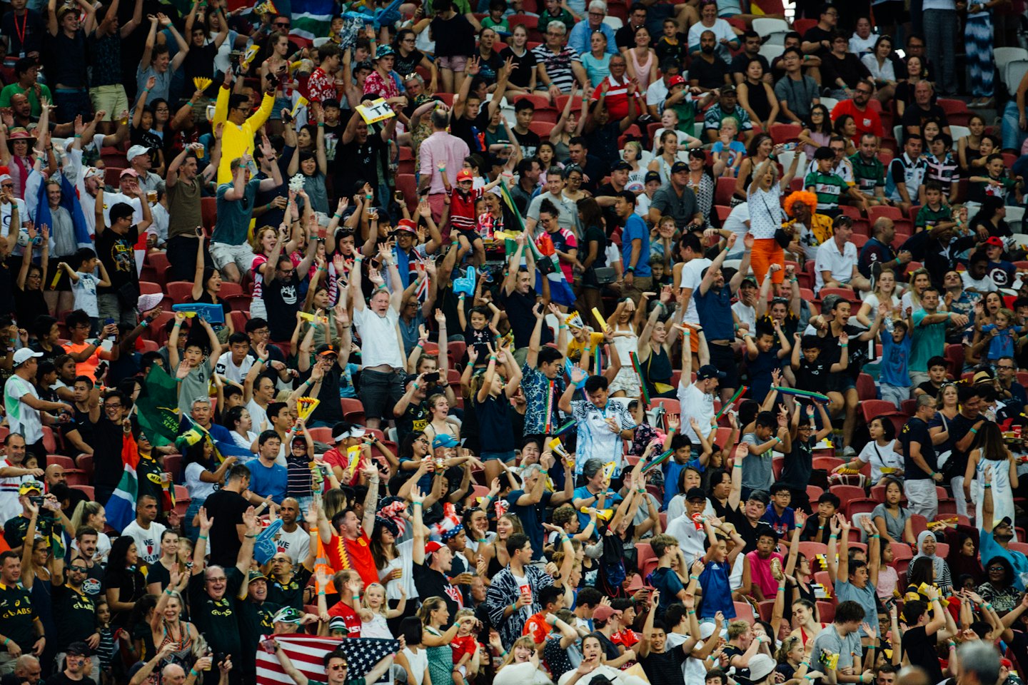 Energetic crowd cheering and celebrating at an outdoor stadium event.